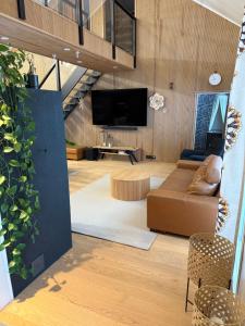a living room with a couch and a tv at Villa Ensola with pool in Savonlinna