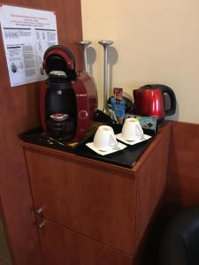 a counter with a coffee maker and two dishes on it at Stacja Grand in Szczecin