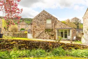 a stone house with a stone wall at The Forge, Snitterton near Matlock in Moffat
