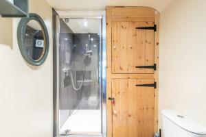 a shower with a glass door in a bathroom at The Forge, Snitterton near Matlock in Moffat +24 photos