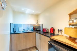 a kitchen with a sink and a microwave at The Forge, Snitterton near Matlock in Moffat