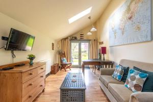 a living room with a couch and a tv at The Forge, Snitterton near Matlock in Moffat
