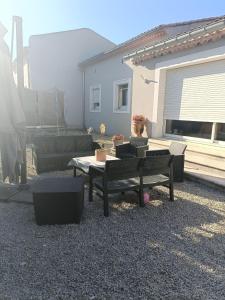 a patio with couches and a table and a couch at Chambre des Iris in Graveson