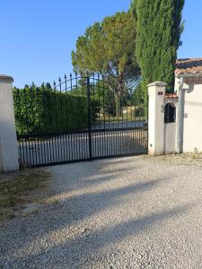 a black fence with a gate in front of a house at Chambre des Iris in Graveson