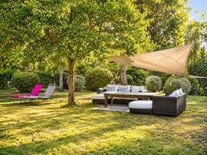 a patio with a couch and chairs in a yard at Château de Lavail in Labastide-dʼAnjou