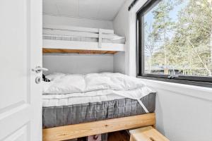 a bed in a small room with a window at 84100-Ebeltoft-Magevej-4 in Ebeltoft