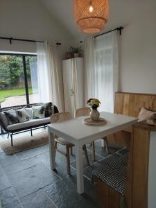 a living room with a table and a couch at Woodville Apartment in Rathmullan +3 photos