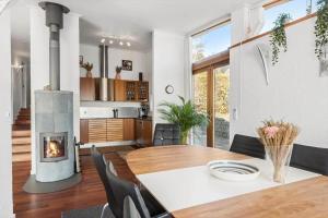 a dining room with a table and a fireplace at 8250-Ega-Strandvangsvej-52 in Egå