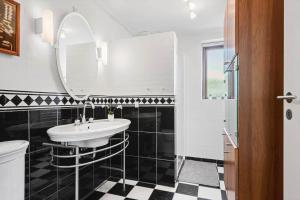 a bathroom with a sink and a mirror at 8250-Ega-Strandvangsvej-52 in Egå +13 photos