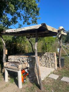 a wooden shelter with a stone wall and a bench at StNicholas Ranch Corfu Wild Camping in Benitses +22 photos