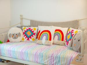 a bed with colorful pillows and a rainbow at 4 Smiddy Hill in Pickering