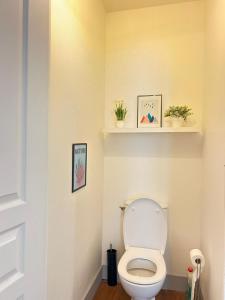 a bathroom with a toilet with two plants on the wall at Cosy Magnolia Quartz - T3 - Hyper centre avec Parking in Pau