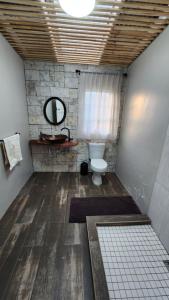 a bathroom with a toilet and a window and a mirror at FinchDen House in Bulawayo