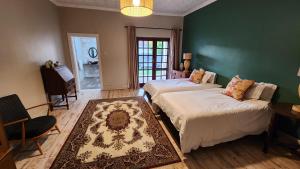 two beds in a room with a green wall at FinchDen House in Bulawayo