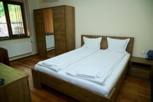a bedroom with a large bed with white sheets at Guest House Fedor in Ribarica
