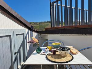 a table on a balcony with a vase of flowers at B&B22 Gammarana - Stazione Teramo in Teramo