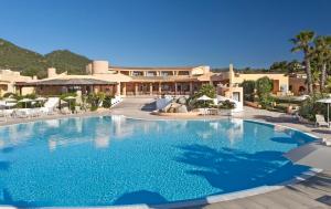 a large swimming pool in front of a resort at Sant'Elmo Beach Hotel in Castiadas