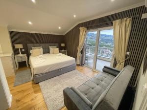 a bedroom with a bed and a couch and a balcony at Casa Del Mar in Ponta do Sol +77 photos