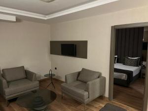 a living room with a couch and a chair and a bed at Adana Time Business Hotel in Adana +11 photos