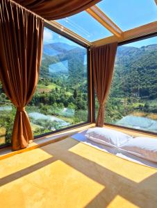 a bedroom with a large window with a mountain view at Glass House Merisi 2 in Merisi