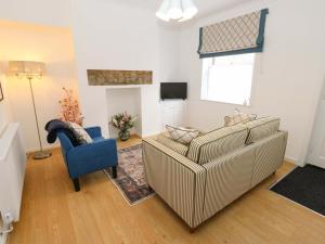 a living room with a couch and a blue chair at Saltaire House in Saltaire