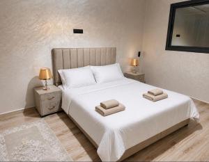 a bedroom with a large white bed with two lamps at Appart Hidaya in Fez