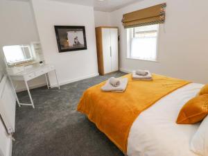 a bedroom with a bed with two towels on it at Saltaire House in Saltaire