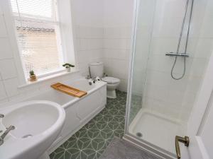 a bathroom with a tub and a toilet and a sink at Saltaire House in Saltaire +30 photos