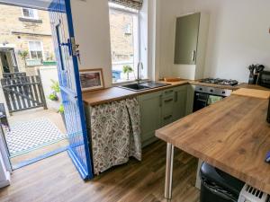 a kitchen with green cabinets and a wooden counter top at Saltaire House in Saltaire