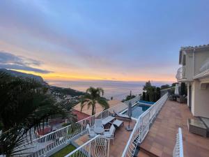 a balcony with a view of the ocean at sunset at Casa Del Mar in Ponta do Sol