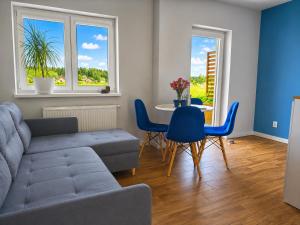 a living room with a couch and a table and chairs at Willa Panorama 881-751-206 in Polańczyk