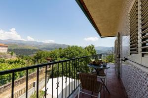 a balcony with a table and a view of the mountains at Casa de Jonathan in Vilarinho do Souto