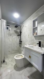 a white bathroom with a toilet and a sink at Welcome to Kobuleti in Kobuleti +40 photos