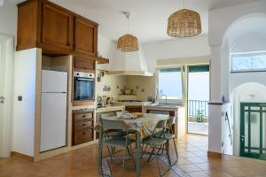 a kitchen with a table and some chairs in it at Casa Ginevra Capri in Capri