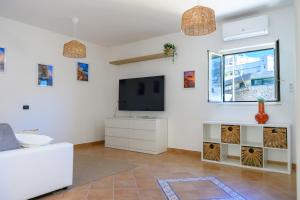 a living room with a tv and a couch at Casa Ginevra Capri in Capri