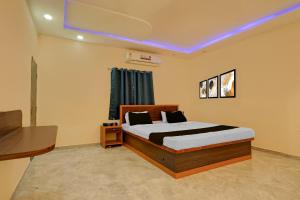 a bedroom with a bed and a table and a window at HOTEL O VILLAGE in Rāipur