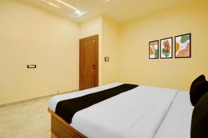 a bedroom with a bed and two pictures on the wall at HOTEL O VILLAGE in Rāipur