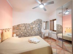 ein Schlafzimmer mit einem Bett und einer Steinwand in der Unterkunft Da Milena in Fonteblanda