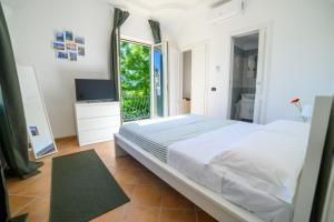 a bedroom with a bed and a large window at Casa Ginevra Capri in Capri