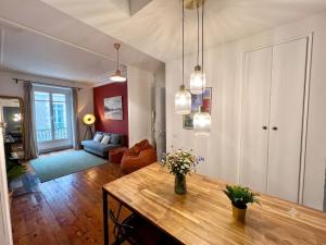 a living room with a table with flowers on it at Cosy Magnolia Quartz - T3 - Hyper centre avec Parking in Pau