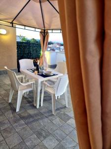 a white table and chairs on a patio at CasaKami Sky Terrace in Nettuno