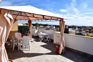 a patio with a white umbrella on a roof at CasaKami Sky Terrace in Nettuno +43 photos