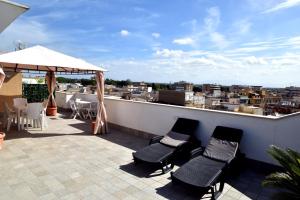 a patio with chairs and an umbrella on a roof at CasaKami Sky Terrace in Nettuno