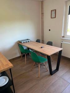 a wooden table with green chairs in a room at Hospodářství u kapličky in Kladeruby nad Oslavou +18 photos