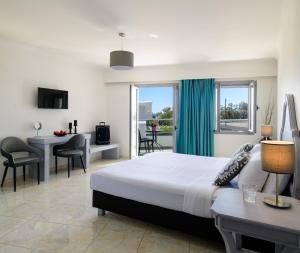 a hotel room with a bed and a table and chairs at Smaragdi in Perivolos