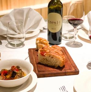 a table with a bottle of wine and a plate of food at Las termas de los Molles in Los Molles +41 photos
