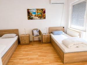 a bedroom with two beds and a chair at Garden Hostel in Skopje