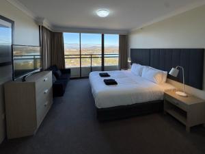 a hotel room with a bed and a large window at Lakefront Panorama – Sky Collection Suite in Canberra +31 photos