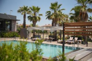 a swimming pool with palm trees in the background at Ayvalık Sea Long in Ayvalık +78 photos