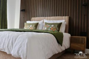 a bedroom with a white bed with green blanket and pillows at The Kings Arms Hotel, Lostwithiel in Lostwithiel +13 photos